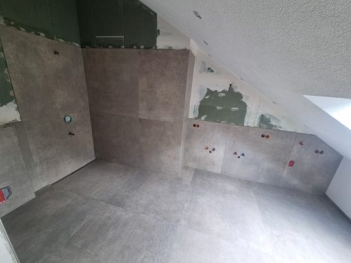 Leerer Raum mit unvollständiger Wandverkleidung und Freilegen von Rohren.