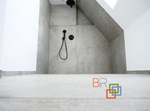 Moderne Dusche in einem minimalistischen, hellen Raum mit grauen Wänden und Duschschlauch.