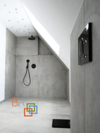 Moderne Duschkabine mit Betonwänden und minimalistischer Ausstattung.