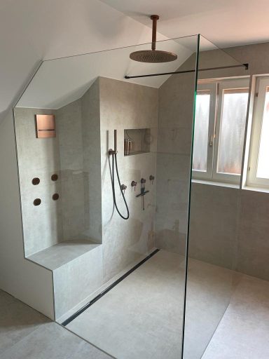 Moderne, barrierefreie Dusche mit Glasabtrennung und Regendusche.